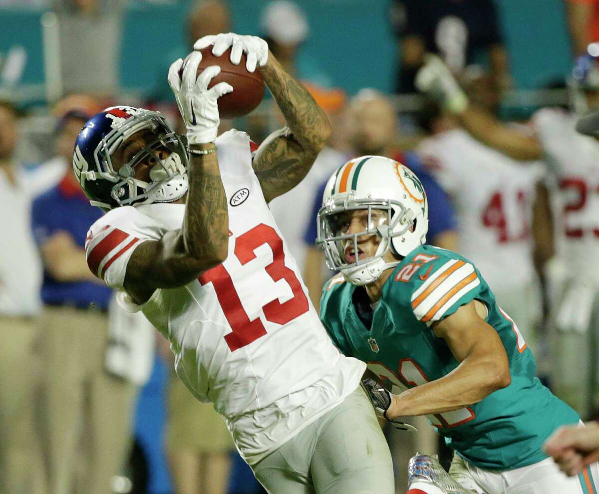 New York Giants wide receiver Odell Beckham (13) makes a catch as Miami Dolphins cornerback Brent Grimes (21) defends, during the first half of an NFL football game, Monday, Dec. 14, 2015, in Miami Gardens, Fla. (AP Photo/Wilfredo Lee)