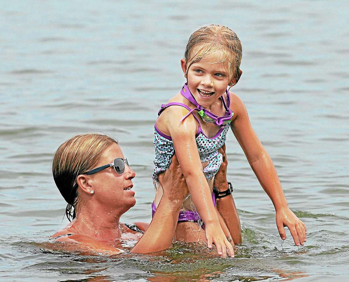 Candy Miller hoists her 5-year old Abbie Miller out of the water at Lake Pocotopaug in East Hampton in this file photo.