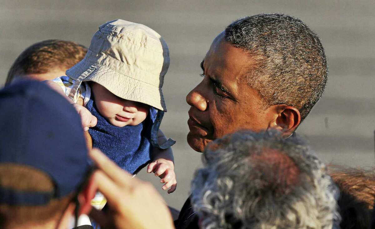 President Obama holds up four-month-old Ryan Kelley, of Richmond, R.I., while greeting a gathering shortly after arriving at T.F. Green Airport in Warwick, R.I. on Aug. 29, 2014. The president traveled to Rhode Island to attend a Democratic fundraiser in Newport on Friday.