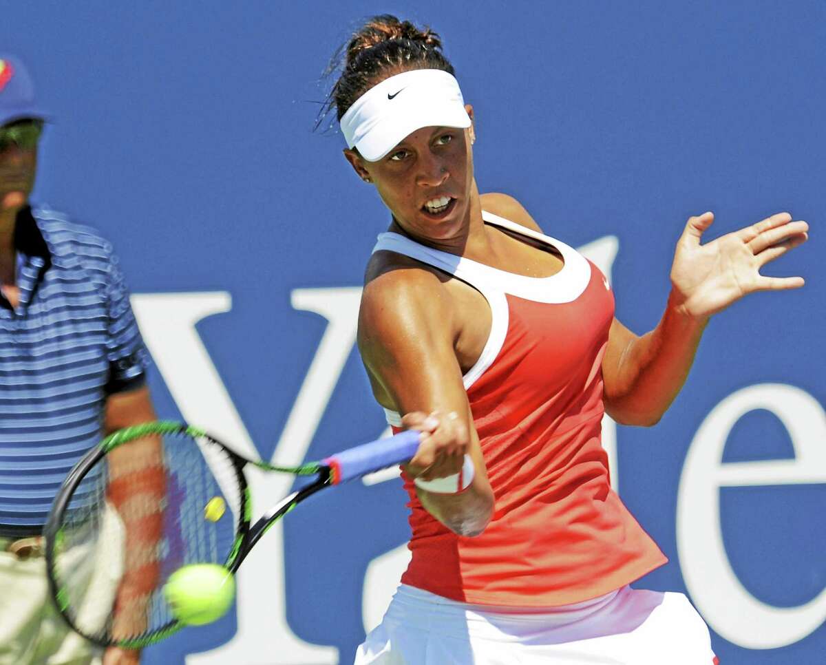 Madison Keys of the USA reaches to hit a return to Elina Svitolina of Ukraine in their singles match at the Connecticut Open in New Haven Monday, Aug. 24, 2015. Photo by Bob Child