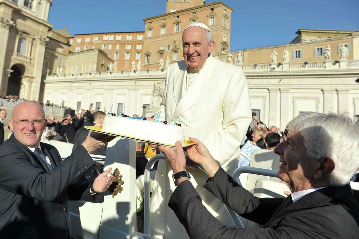 In this photo provided by Vatican newspaper L'Osservatore Romano, Pope Francis is presented with a cake during his weekly general audience in St. Peter's Square at the Vatican, Wednesday, Dec. 17, 2014. Pope Francis got a cake, cards and a tango demonstration for his 78th birthday Wednesday, and 800 kilograms of chicken meat for the poor. (AP Photo/L'Osservatore Romano)