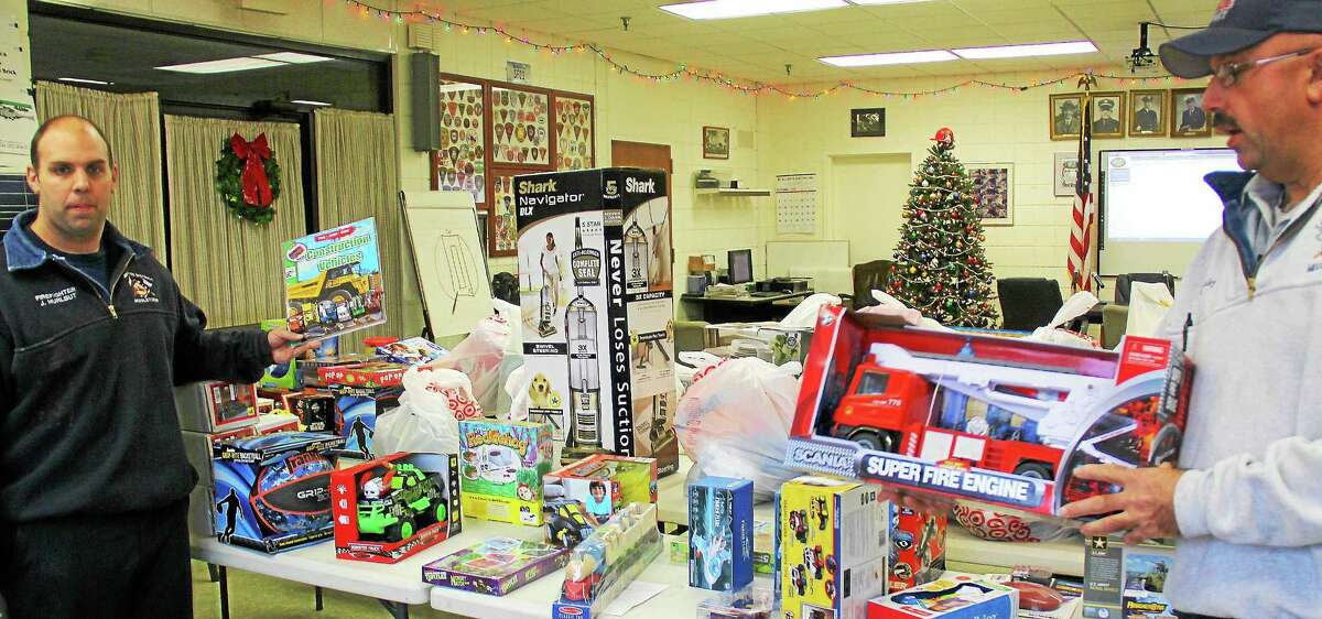 South District firefighters display some of the donated presents ready to surprise Middletown children. Unwrapped gifts, wrapping paper, and cash donations are being accepted at the station through Wednesday.