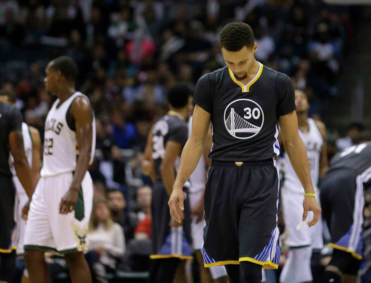 The Warriors’ Stephen Curry looks down during the second half Saturday’s loss to the Bucks.