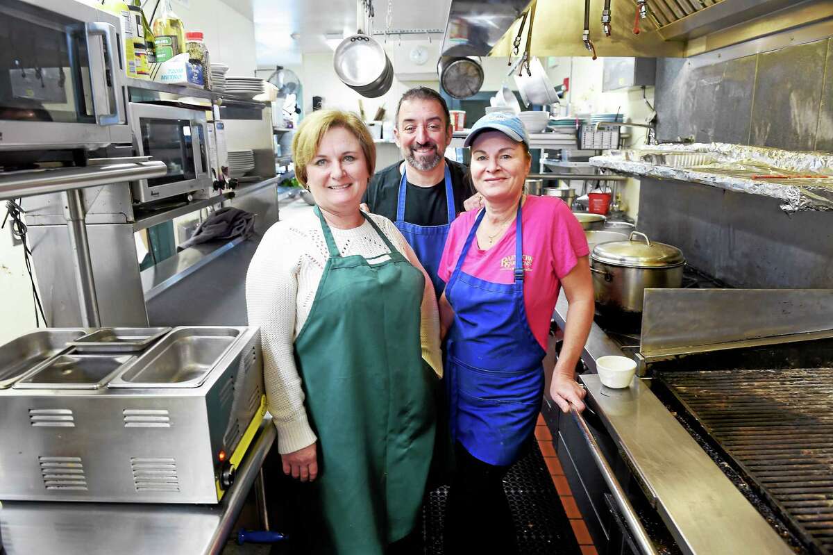 (Arnold Gold-New Haven Register) From left, Rainbow Gardens Restaurant & Bar owners Heather Profetto, her husband, John, and head chef Kate Campbell pause in the restaurant’s kitchen in Milford.