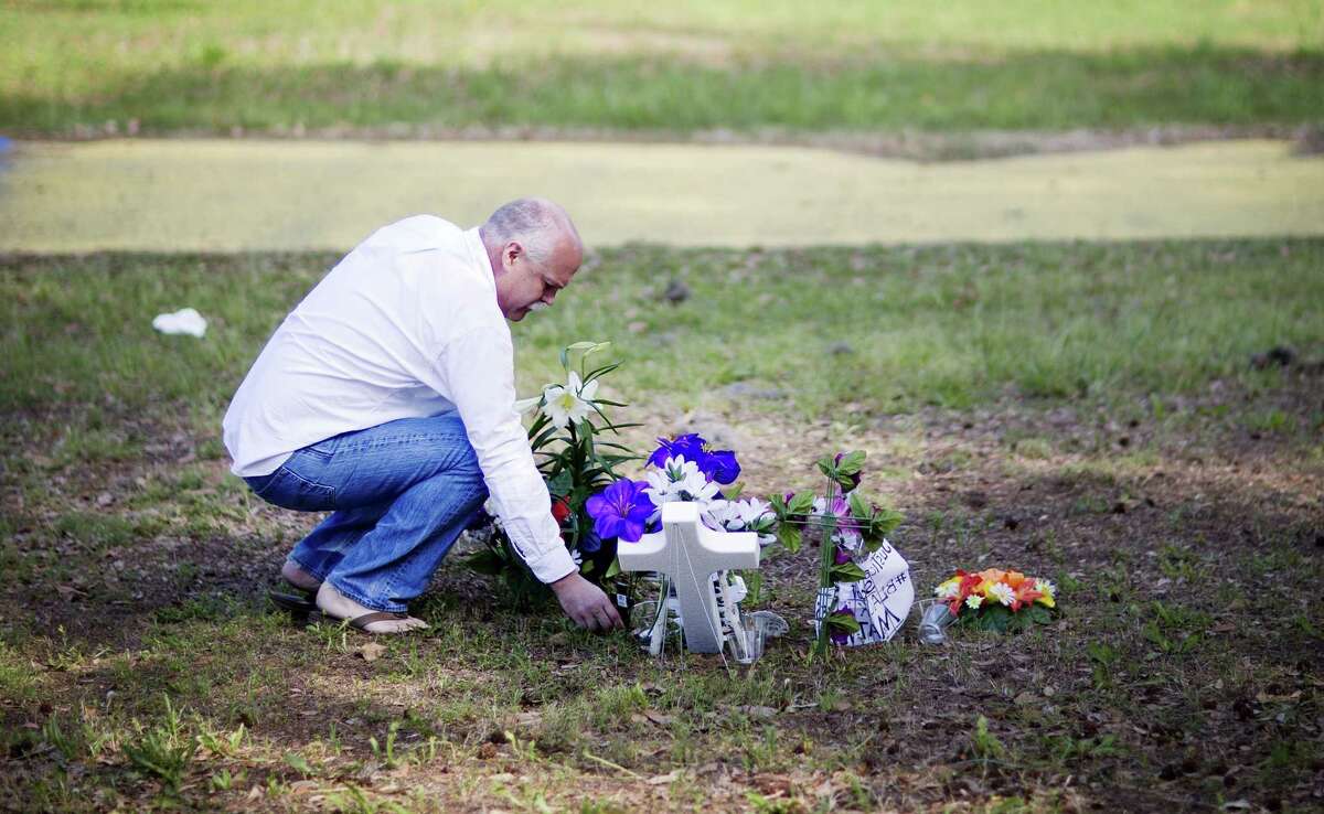 Jeffrey Spell, of Charleston, S.C., places flowers on Thursday at the scene where Walter Scott was killed by a North Charleston police officer Saturday after a traffic stop in North Charleston, S.C.