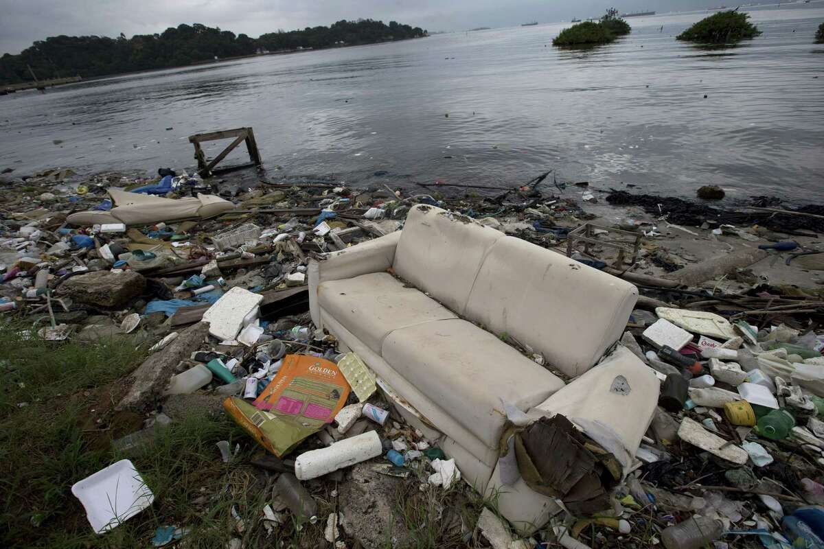In this June 1 file photo, a discarded sofa litters the shore of Guanabara Bay in Rio de Janeiro. As part of its Olympic bid, Brazil promised to build eight treatment facilities to filter out much of the sewage and prevent tons of household trash from flowing into the bay. Only one has been built.