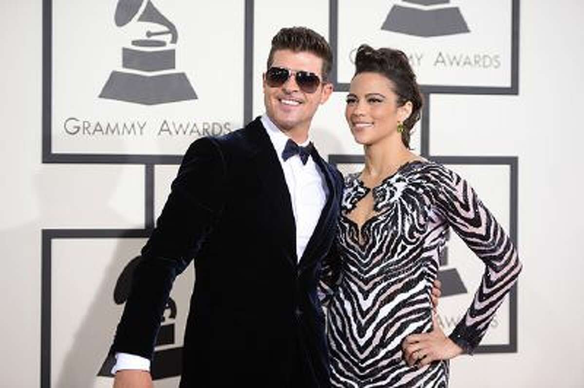 Nominee For Best Pop Vocal Album for "Blurred Lines" Robin Thicke (L) and actress Paula Patton arrive on the red carpet for the 56th Grammy Awards at the Staples Center in Los Angeles, California, January 26, 2014. AFP PHOTO ROBYN BECK (Photo credit should read ROBYN BECK/AFP/Getty Images)