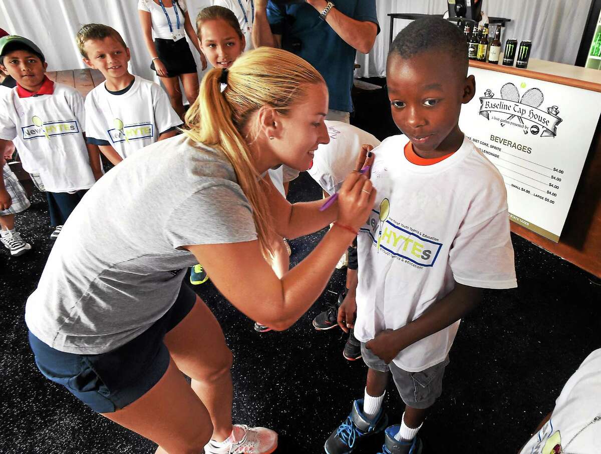 Dominika Cibulkova, the fifth seed at the Connecticut Open, signs the T-shirt of Martin Duff of New Haven, 9, a member of New Haven Youth Tennis & Education, or New HYTEs, after the draw ceremony. Cibulkova will face Andrea Petkovic in the first round.