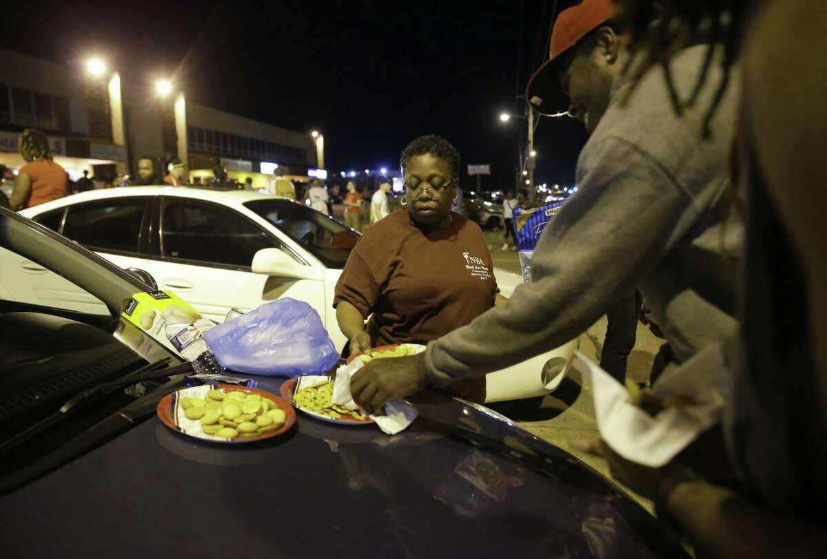 Cat Daniels puts out snacks as a smaller group of protesters gathers along West Florissant Avenue in Ferguson, Mo., Tuesday, Aug. 11, 2015. The St. Louis suburb has seen demonstrations for days marking the anniversary of the death of 18-year-old Michael Brown, whose shooting death by a Ferguson police officer sparked a national “Black Lives Matter” movement. Tuesday was the fifth consecutive night a crowd gathered on West Florissant.