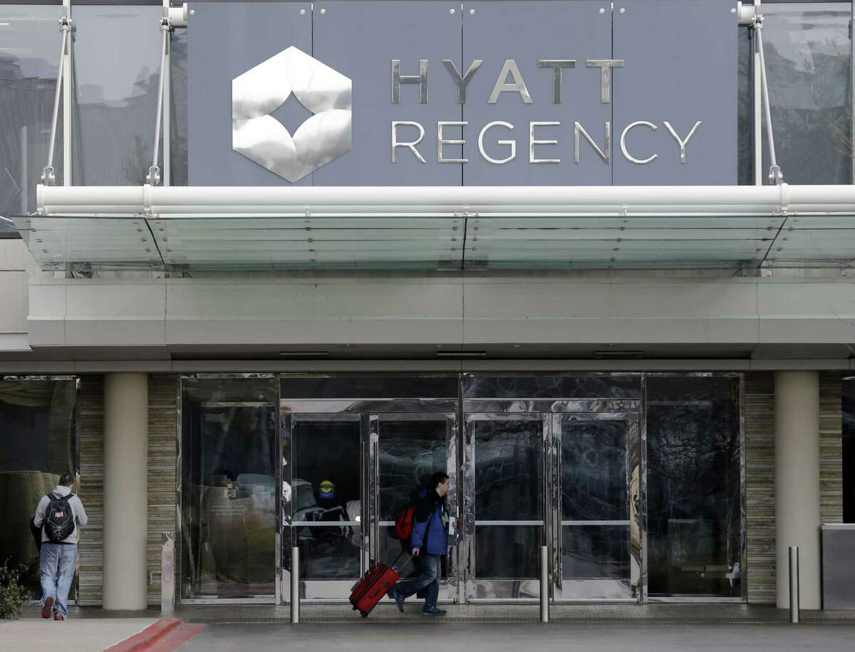 Travelers walk at the Hyatt Regency O’Hare in Rosemont, Ill., on Sunday, Dec. 7, 2014. Thousands of people were evacuated after an chlorine gas leak at the Hyatt hotel hosting the 2014 Midwest FurFest convention. (AP Photo/Nam Y. Huh)