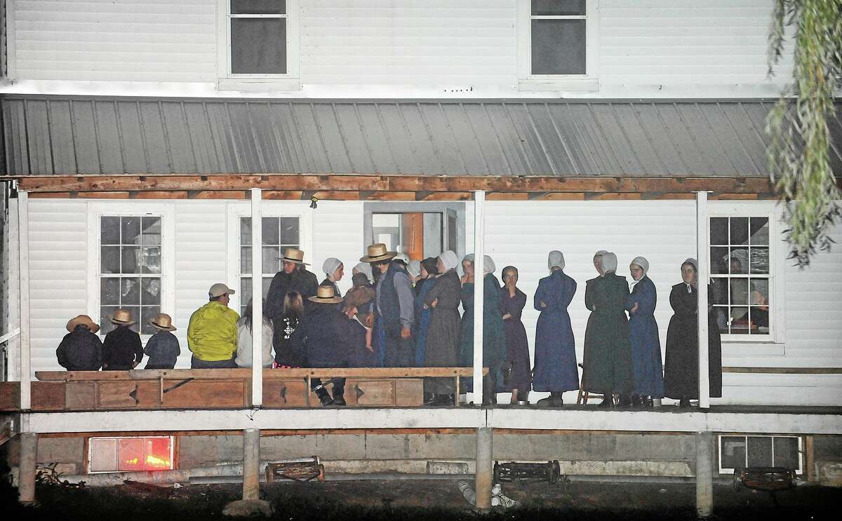 Supporters gather on the porch of a house at the intersection of Route 812 and Mt. Alone Road in Heuvelton, NY on Thursday, Aug. 14, 2014 after Fannie Miller, 12, and her sister Delila Miller, 6, were returned home safely after being abducted Wednesday night at a farm stand near their home. (AP Photo/The Watertown Daily Times, Jason Hunter)