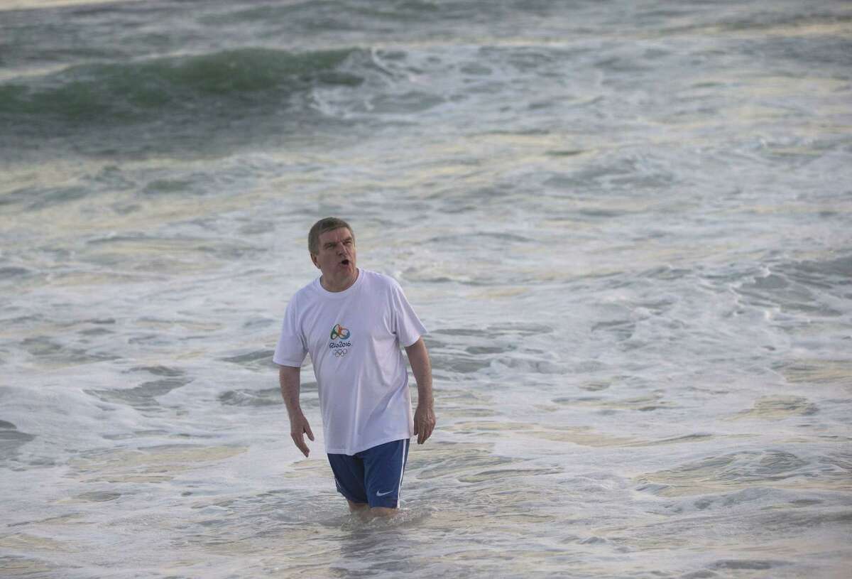 International Olympic Committee President Thomas Bach bathes in the waters of the Barra de Tijuca beach during a meeting with current and former Brazilian Olympic athletes in Rio de Janeiro, Brazil, Tuesday, Aug. 4, 2015. With the Olympic games being almost a year away, Bach played on the beach and bathed in the water, even after an AP investigation showed that all Olympic water venues had dangerously high viral levels, according to water safety experts who reviewed the data.