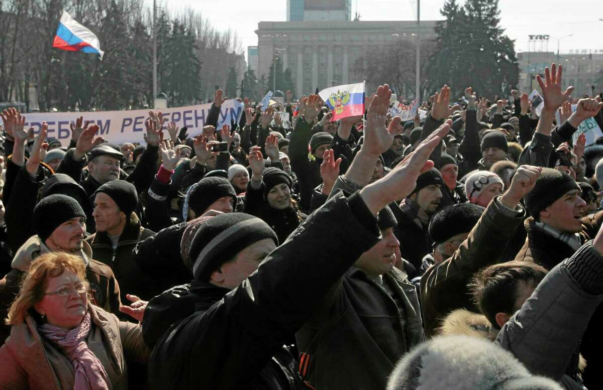 People gesture during a pro Russian rally at a central square in Donetsk, Ukraine, Saturday, March 8, 2014. Pro Russian activists continued to gather on Saturday in the eastern Ukrainian city of Donetsk, as Russia was reported to be reinforcing its military presence in Crimea.