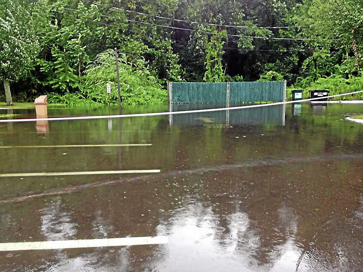 The parking lot of a Dunkin’ Donuts store in Branford was roped off Wednesday morning because of flooding as severe storms pounded the state’s coastline.