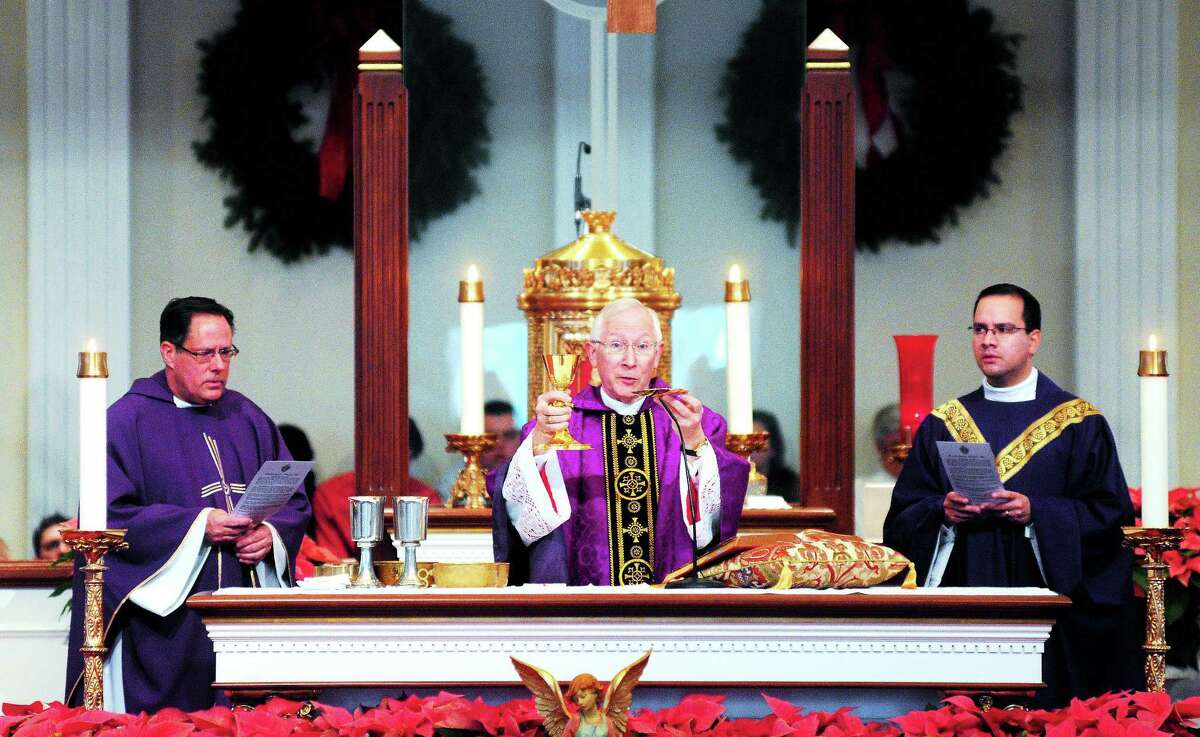(Arnold Gold — New Haven Register) Archbishop Leonard Blair, center, celebrated Mass at St. George Church in Guilford in December.