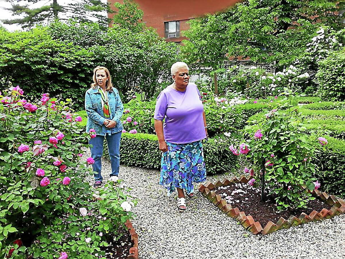 Ghosts of New England Research Society Clairaudient Medium Karen Hollis and Butler-McCook House Site administrator Jackie McKinney take a pre-investigation tour in the rose garden of the property in Hartford.