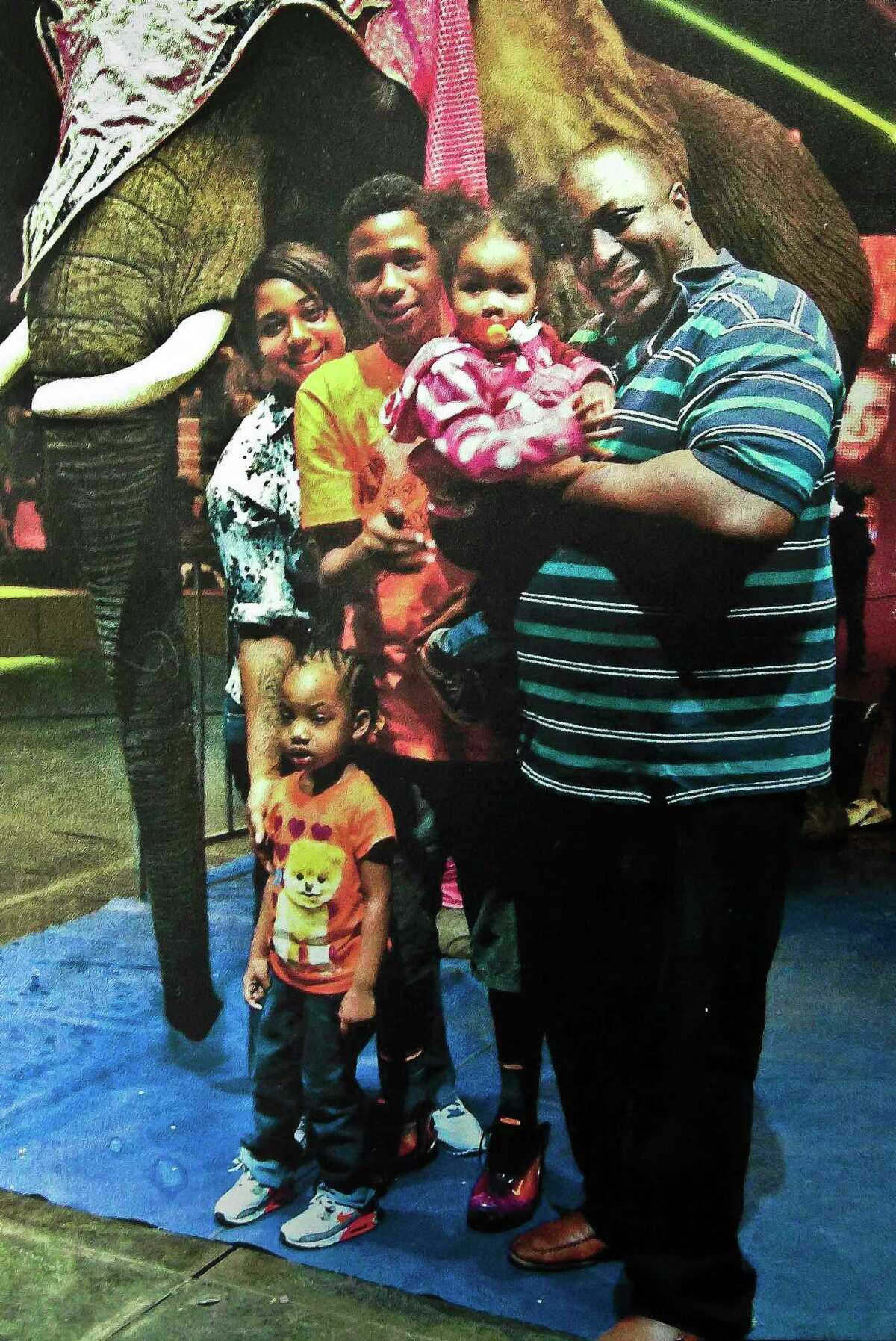 In this undated family file photo provided by the National Action Network, Saturday, July 19, 2014, Eric Garner, right, poses with his children during a family outing.