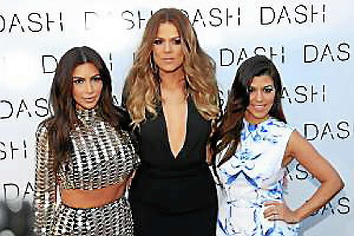 From left, Kim Kardashian, Khloe Kardashian and Kourtney Kardashian attend The Kardashian Family Celebrates the Grand Opening of DASH Miami Beach on Wednesday, March 12, 2014, in Miami Beach, Fla.