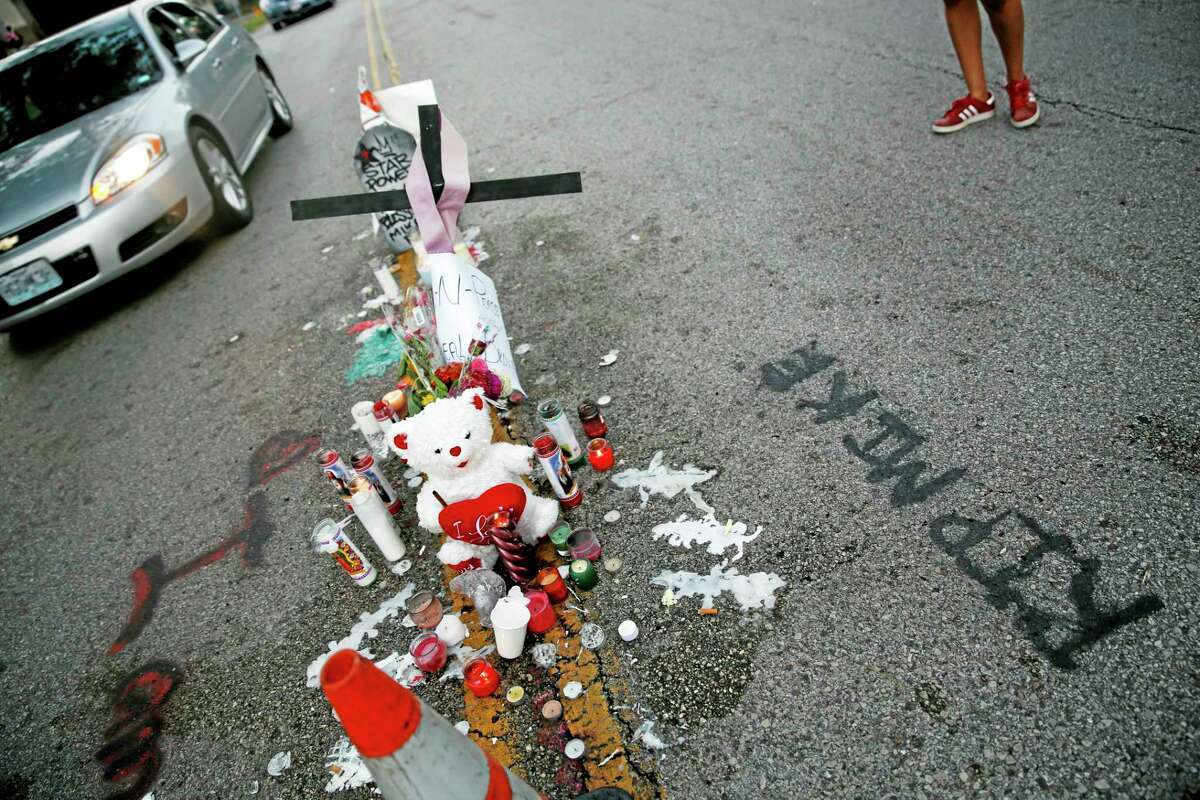 A makeshift memorial sits in the middle of the street where 18-year-old Michael Brown was shot and killed by police Monday, Aug. 11, 2014, in Ferguson, Mo. The FBI has opened an investigation into the fatal shooting of an unarmed black teenager on Saturday whose death stirred unrest in a St. Louis suburb. (AP Photo/Jeff Roberson)