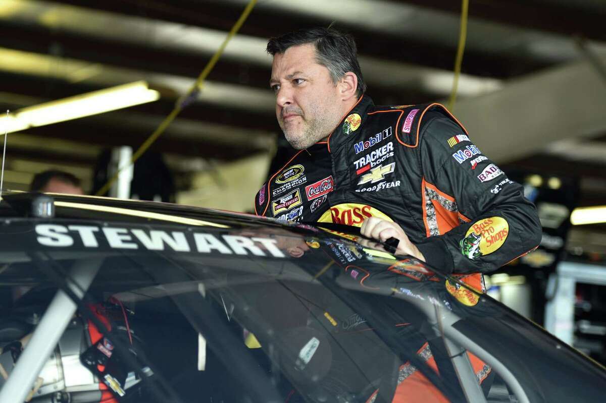 Tony Stewart climbs into his car before practice for Sunday’s NASCAR Sprint Cup race at Watkins Glen International on Friday in Watkins Glen, N.Y.