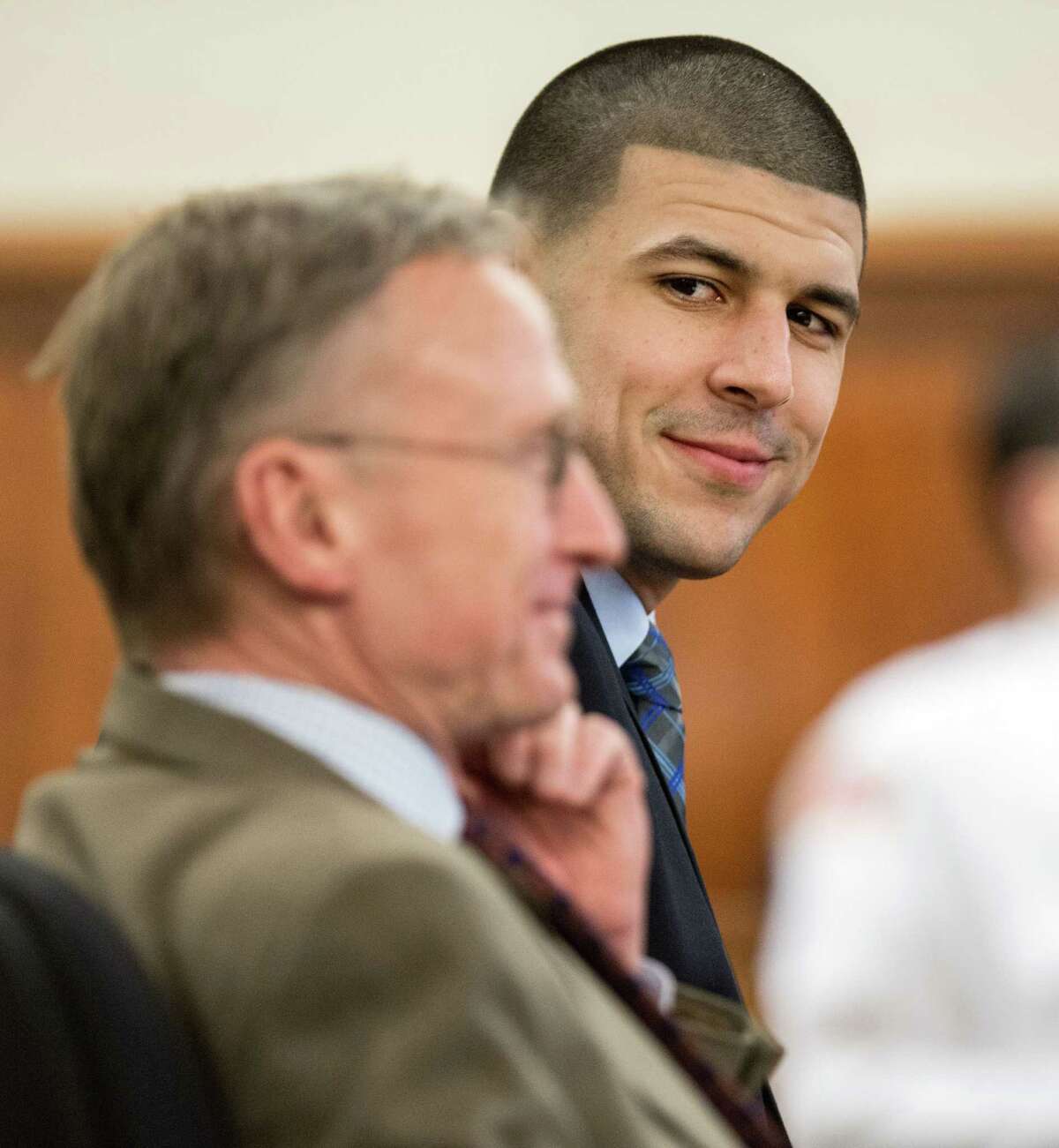 Former New England Patriots football player Aaron Hernandez, right, smiles at his attorney Charles Rankin during his murder trial, Tuesday, March 31, 2015, at Bristol County Superior Court in Fall River, Mass. Hernandez is accused of killing Odin Lloyd in June 2013. (AP Photo/The Boston Globe, Aram Boghosian, Pool)