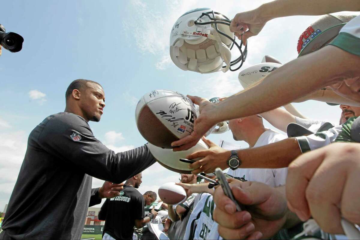 New York Jets cornerback Dee Milliner signs autographs earlier in training camp.