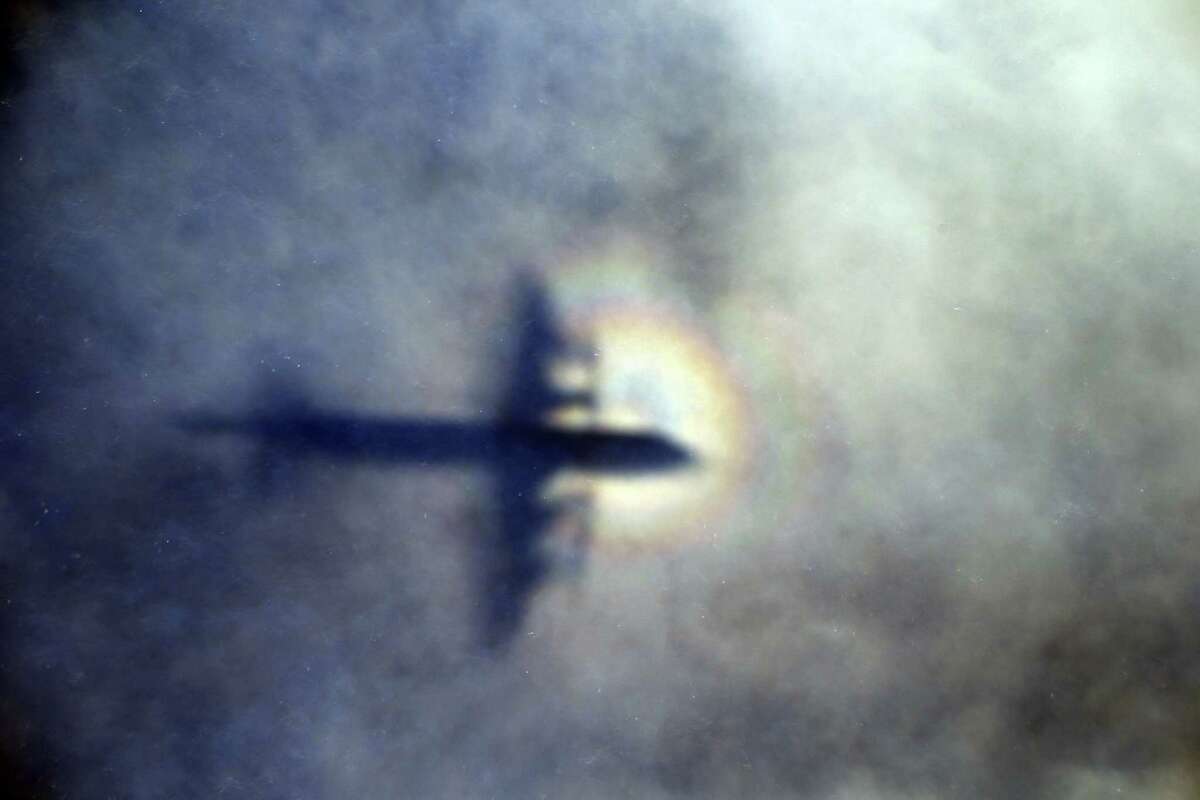 In this March 31, 2014, photo, the shadow of a Royal New Zealand Air Force P3 Orion is seen on low level clouds while the aircraft searches for missing Malaysia Airlines Flight 370 in the southern Indian Ocean, near the coast of Western Australia. Malaysian Prime Minister Najib Razak announced on Thursday, Aug. 6, 2015, that a wing piece that washed up on Reunion Island last week is from the missing flight. However, French, U.S. and Australian authorities stopped short of full confirmation, frustrating relatives with mixed messages.