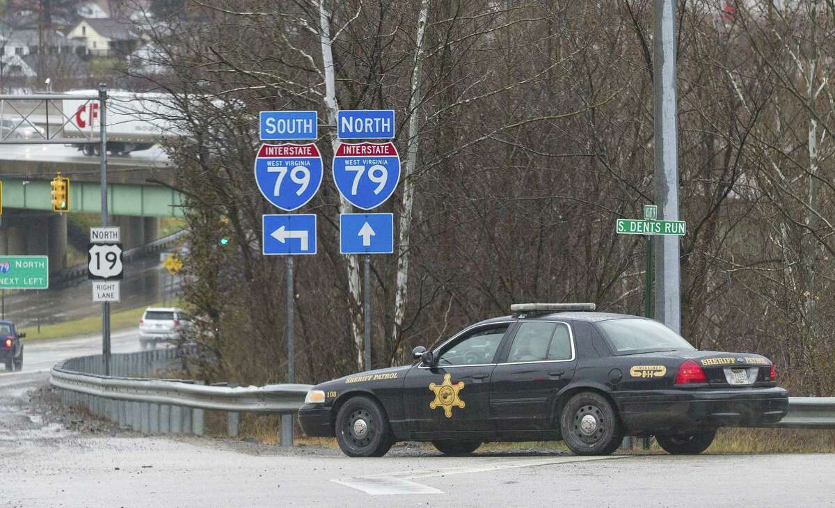 A Sheriffs department patrol car is parked on the exit ramp of exit 155 of I-79 in Morgantown, W.V., Monday, Dec. 1, 2014, after three separate shootings left four people dead on Monday.