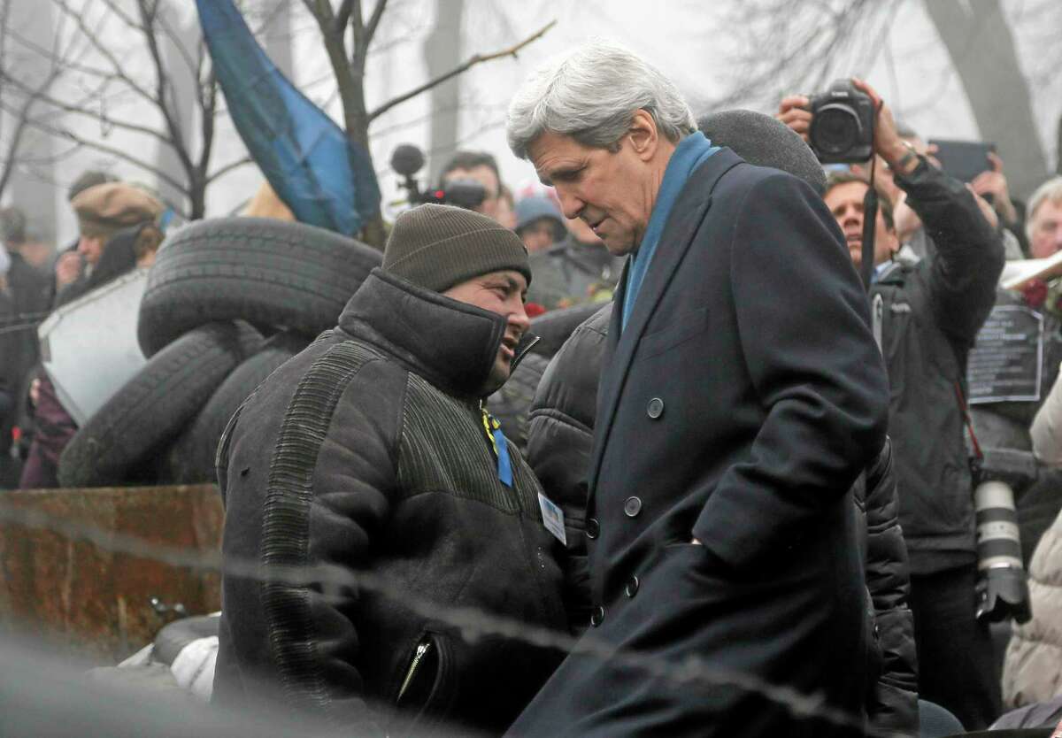 U.S. Secretary of State John Kerry, right, inspects protesters barricades in Kiev, Ukraine, Tuesday, March, 4, 2014. In a somber show of U.S. support for Ukraineís new leadership, Secretary of State John Kerry walked the streets Tuesday where nearly 100 anti-government protesters were gunned down by police last month, and promised beseeching crowds that American aid is on the way. The Obama administration announced a $1 billion energy subsidy package in Washington as Kerry was arriving in Kiev.(AP Photo/Efrem Lukatsky)