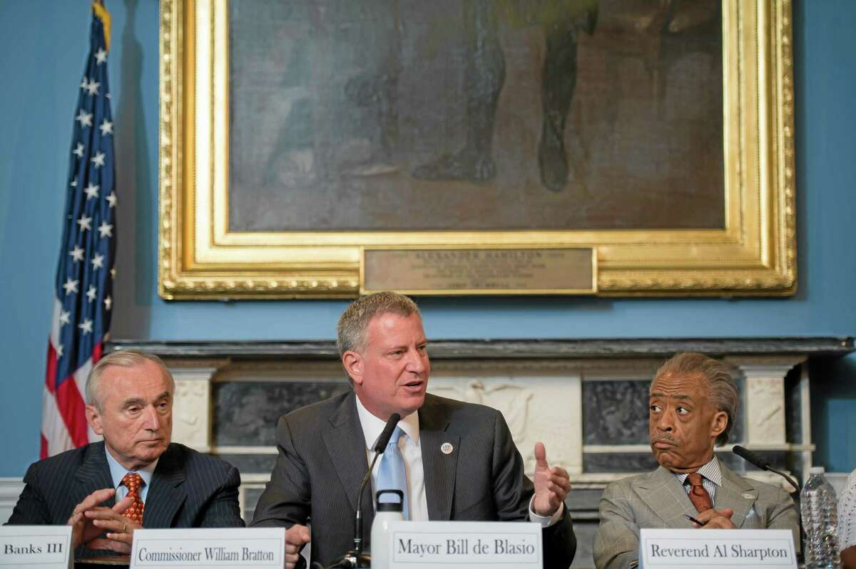 FILE- In this July 31, 2014 file photo provided by the New York City Mayoral Photography Office, New York Mayor Bill de Blasio, center, is seated between New York City Police Commissioner William Bratton, left, and the Rev. Al Sharpton, during a round table discussion convened to ease tensions over the July 17, police involved death of Eric Garner. In an interview with The Associated Press, Police Commissioner Bill Bratton said he wanted to counter "some of the misimpressions and some of the momentum that's been gained by self-serving interests" in the wake of the videotaped death last month of Garner. (AP Photo/New York City Mayoral Photography Office, Bob Bennett, File)