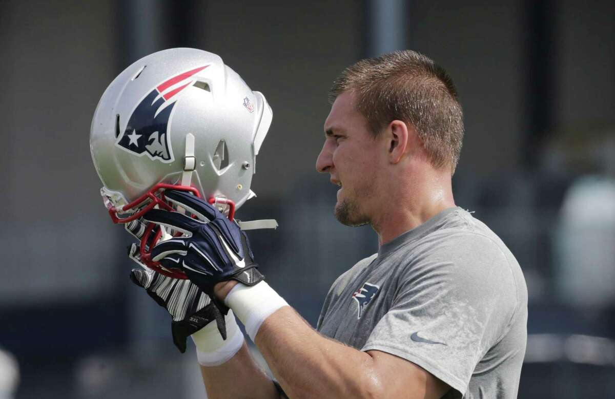 New England Patriots tight end Rob Gronkowski puts on his helmet during training camp on Thursday in Foxborough, Mass.