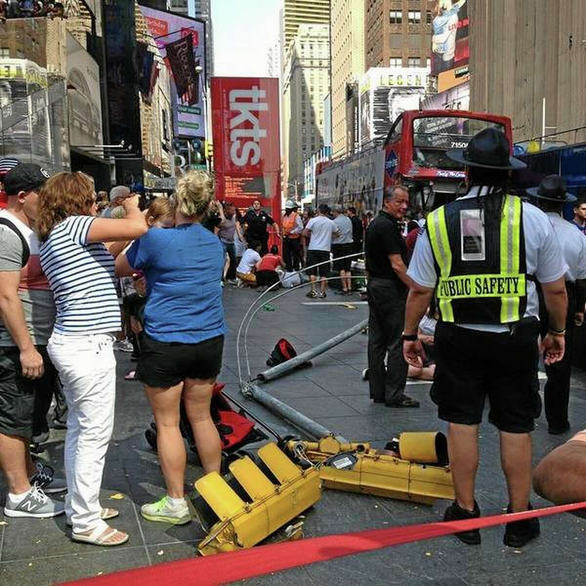 In this photo provided by Josh Price, pedestrians gather at the scene of a bus crash as first responders attend to the victims, Tuesday, Aug. 5, 2014, in New York Cityís Times Square. The Theater District collision of two double-decker tour buses injured more than a dozen people. (AP Photo/Josh Price)