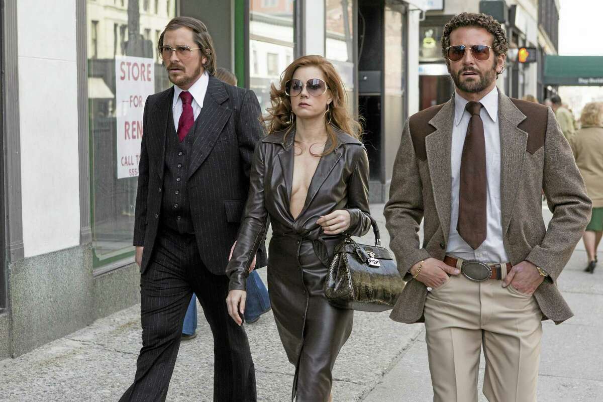 This photo released by Sony Pictures shows Christian Bale, left, as Irving Rosenfeld, Amy Adams as Sydney Prosser, and Bradley Cooper as Richie Dimaso walking down Lexington Avenue in a scene from Columbia Pictures’ film, “American Hustle.”