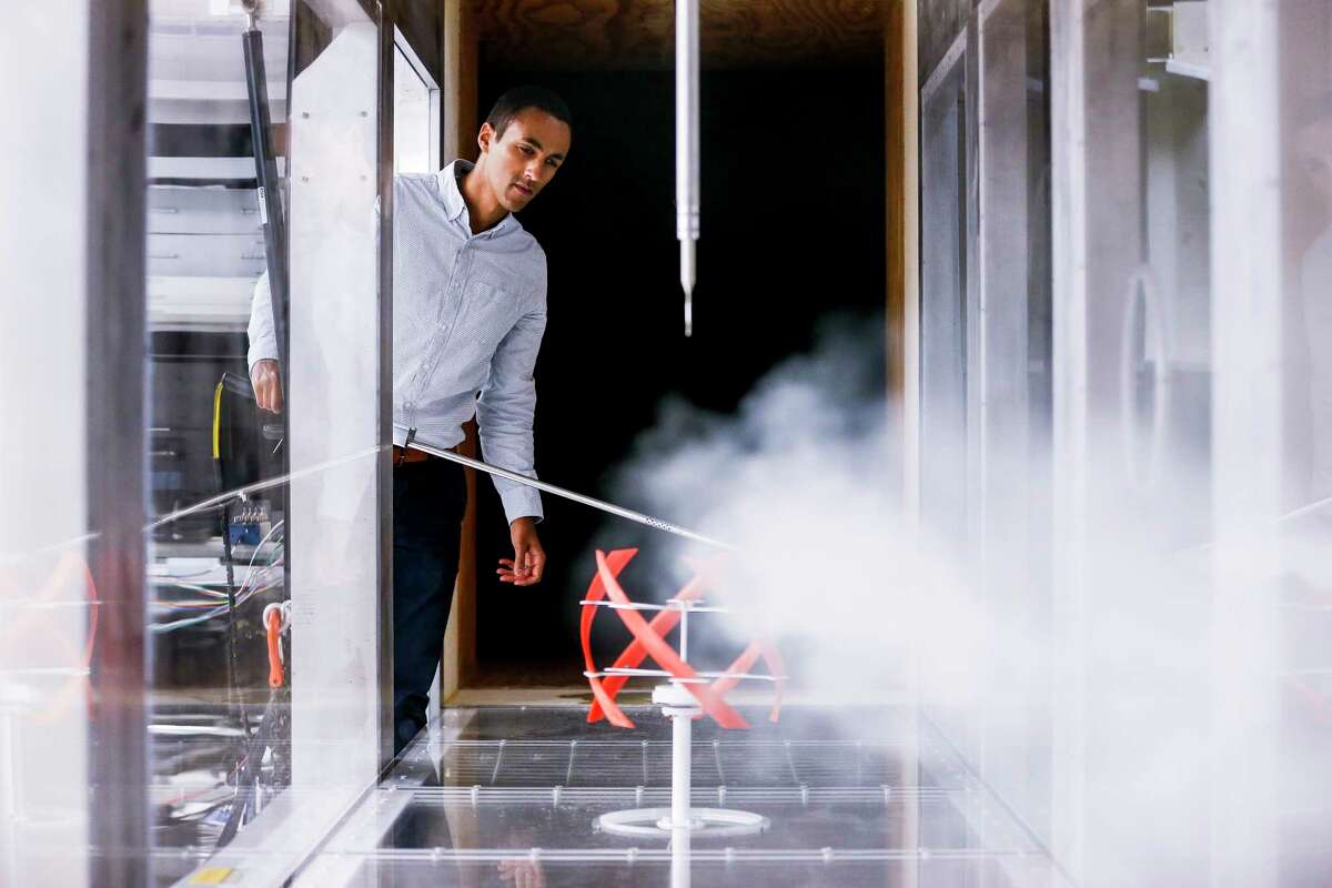 Daniel Araya, an assistant professor of mechanical engineering at the University of Houston, adjusts a stream of smoke in a wind tunnel to observe the way air currents interact with a 3-D printed model of a helical-shaped wind turbine.