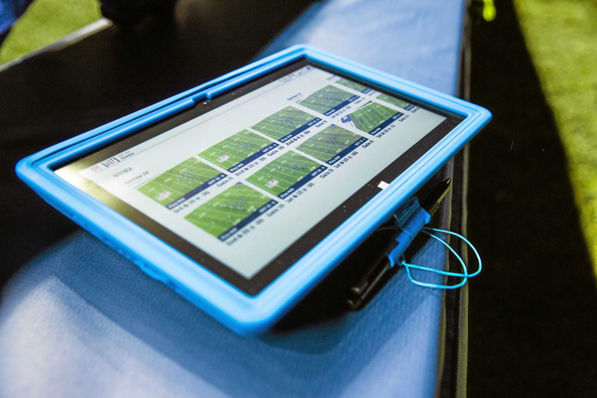 A Microsoft Surface is used for instant replays, on the sideline of an NFL  football game