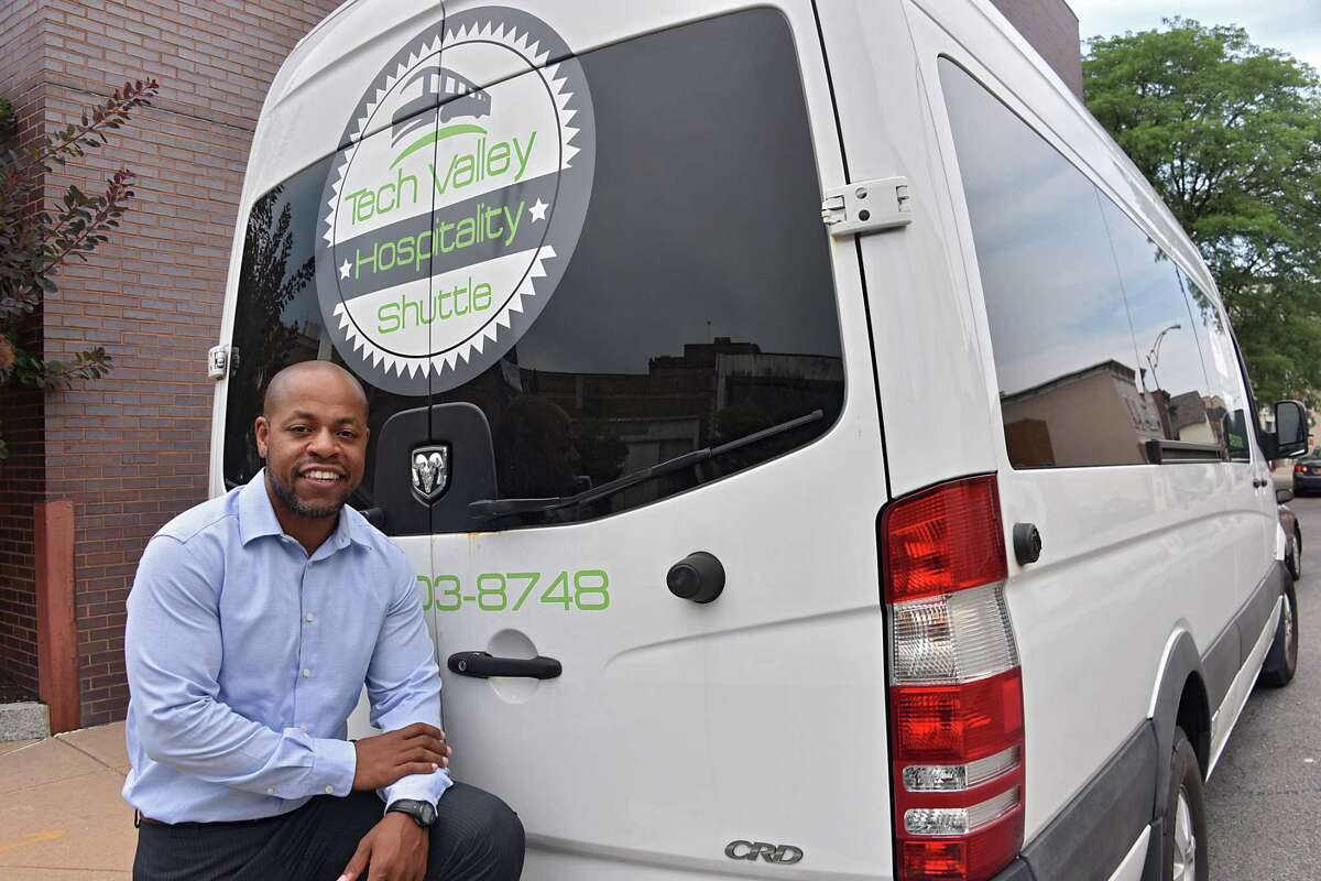 Trent Griffin-Braaf stands next to one of three shuttles he owns on Wednesday Aug. 2, 2017 in Schenectady, N.Y. The Schenectady man went from serving time in prison to working as a hotel janitor to owning his own shuttle business, Tech Valley Hospitality Shuttle. (Lori Van Buren / Times Union)