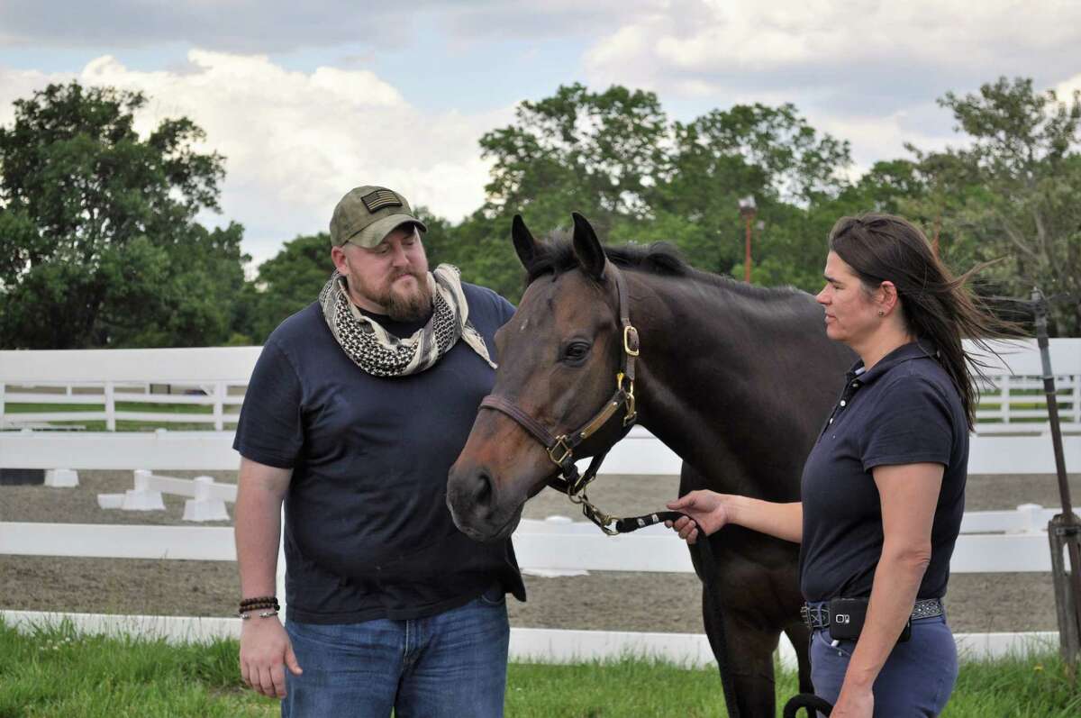 Retired Marine Sgt. Matt Ryba with Crafty Star, a 9-year-old retired race horse, and a staff member at the Bergen Equestrian Center in New Jersey, where the Man O' War program runs. (Provided)