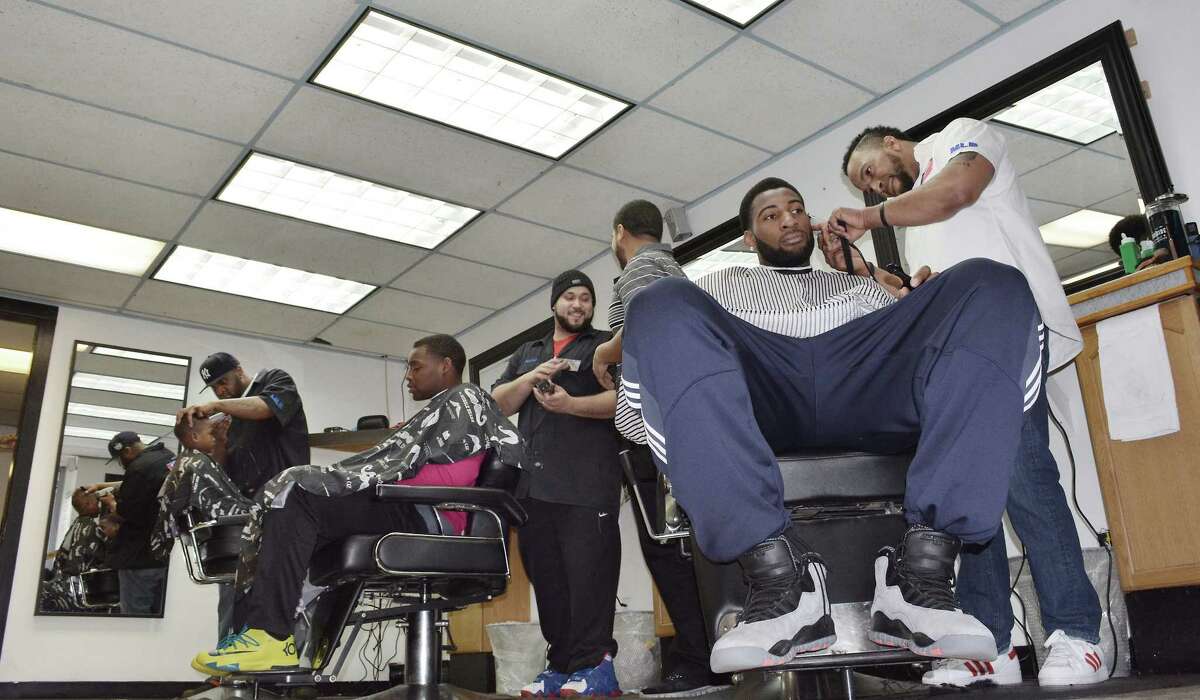 Vernon S. McDaniel Sr., owner of Major League Barber Shop on William Street in Middletown, finishes up Middletown native and Detroit Piston center Andre Drummond Friday afternoon.