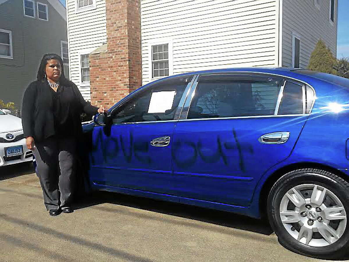 Lawanda Perry stands by her Nissan Altima, which has now sustained racist vandalism on at least two occasions. Her family painted the car blue after a prior attack. Perry said the vandals struck two nights in a row this week.