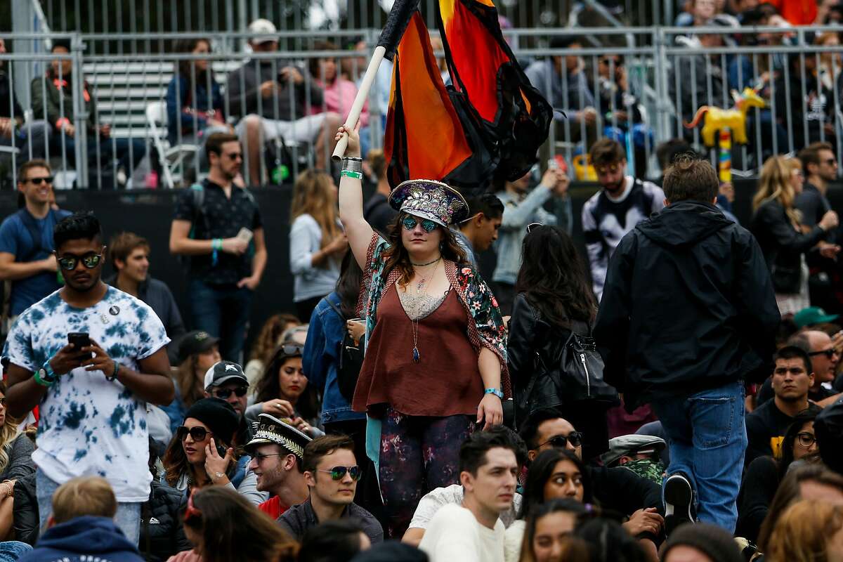 A woman holds up a flag during the Thundercat concert on the Twin Peaks stage during the 10th annual Outside Lands Festival in Golden Gate Park in San Francisco on Saturday, August 12, 2017.