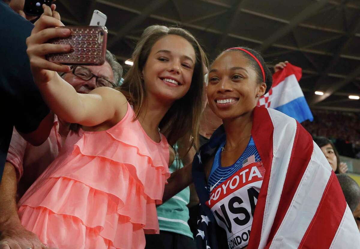 United States' gold medal winner Allyson Felix has a selfie taken as she celebrates with fans after the women's 4x400-meter relay final during the World Athletics Championships in London Sunday, Aug. 13, 2017. (AP Photo/Kirsty Wigglesworth)