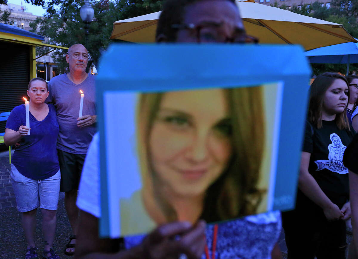 Lisa Malick (from left), Adam Suson, Pauline Dejear, holding a photo of Heather Heyer, and others attend a candle light vigil held Sunday Aug. 13, 2017 at Travis Park, for the victims in Charlottesville, Va. Heyer was killed during an anti-white-nationalist protest in Charlottesville, Va.,