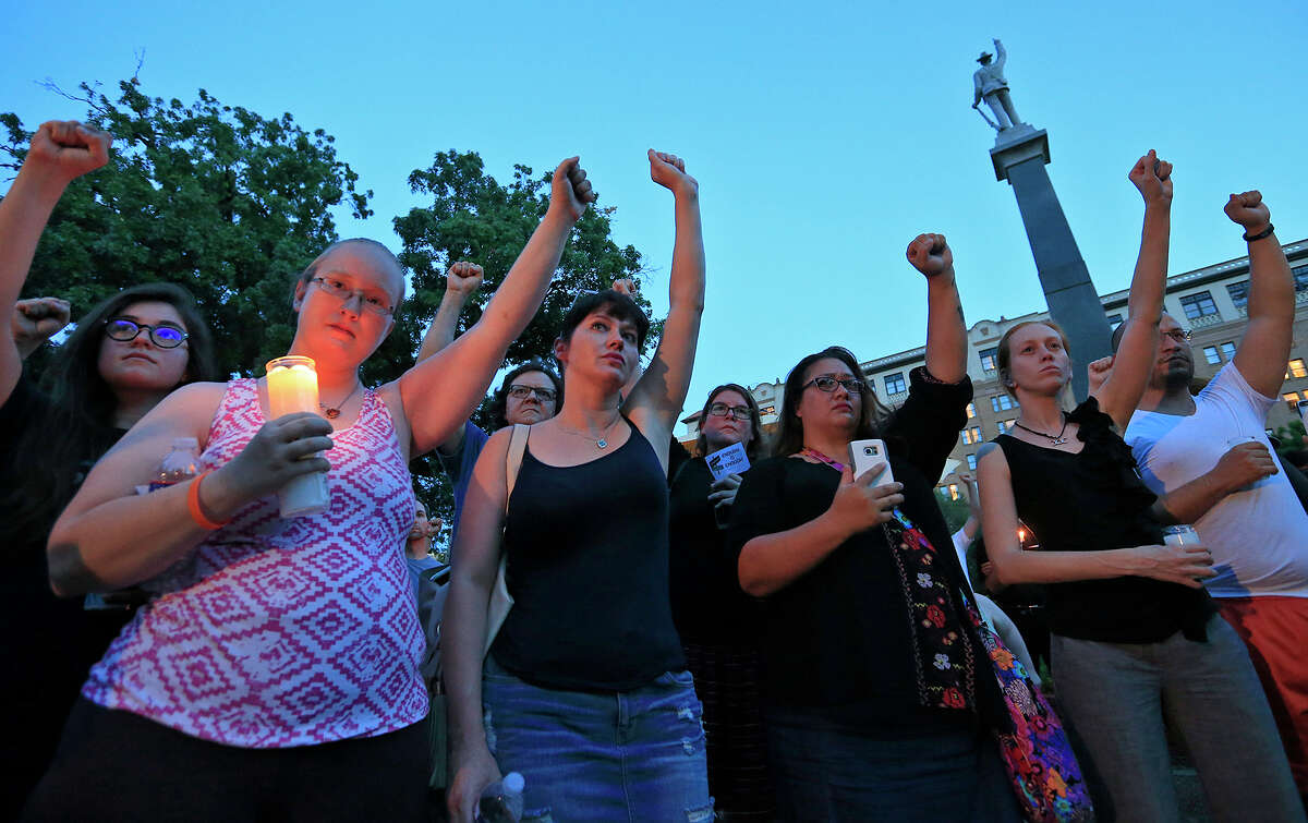 People attend a candle light vigil, Sunday Aug. 13, 2017 at Travis Park, for the victims in Charlottesville, Va. A monument and statue of a Confederate soldier (background) was the subject of a rally that brought about 500 hundred protesters to the park the day prior. Click through the slideshow to view some places in Texas where remnants of the Confederacy are alive and well.