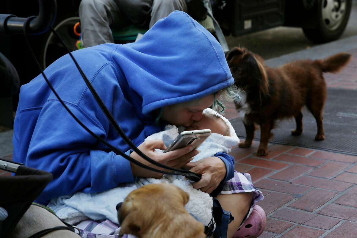 Some panhandling moms are not really homeless, unlike Megan Doudney, on Market Street last month with her baby.