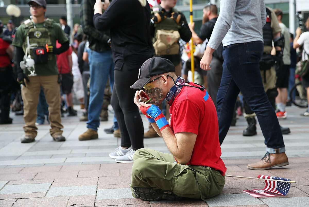 A far right, Trump supporter smokes a bowl during "Patriot Prayer" on Sunday, Aug. 13, 2017. (GRANT HINDSLEY, seattlepi.com)