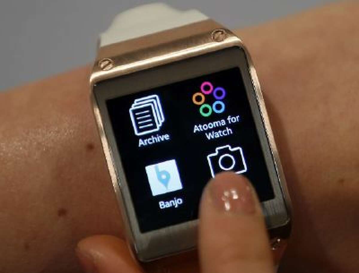 In this Wednesday, Sept. 4, 2013 photo, a model touches the screen of a Samsung Galaxy Gear smartwatch in Berlin, Germany.