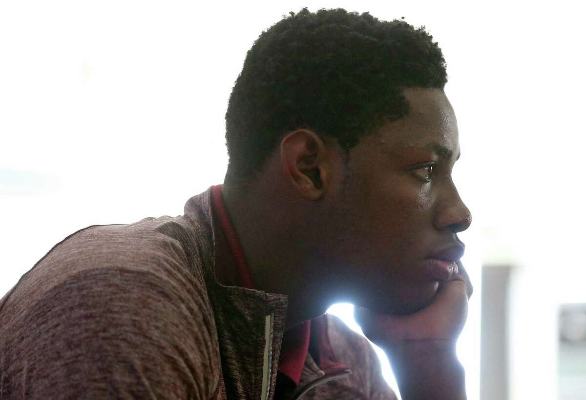 St. Anthony basketball player Charles Bassey watches a video during world history class at the school in February 2017.