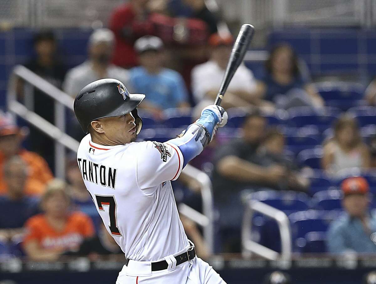 Miami Marlins right fielder Giancarlo Stanton hits a single during the first inning of a baseball game against the San Francisco Giants, Tuesday, Aug. 15, 2017 in Miami. (Pedro Portal/Miami Herald via AP)