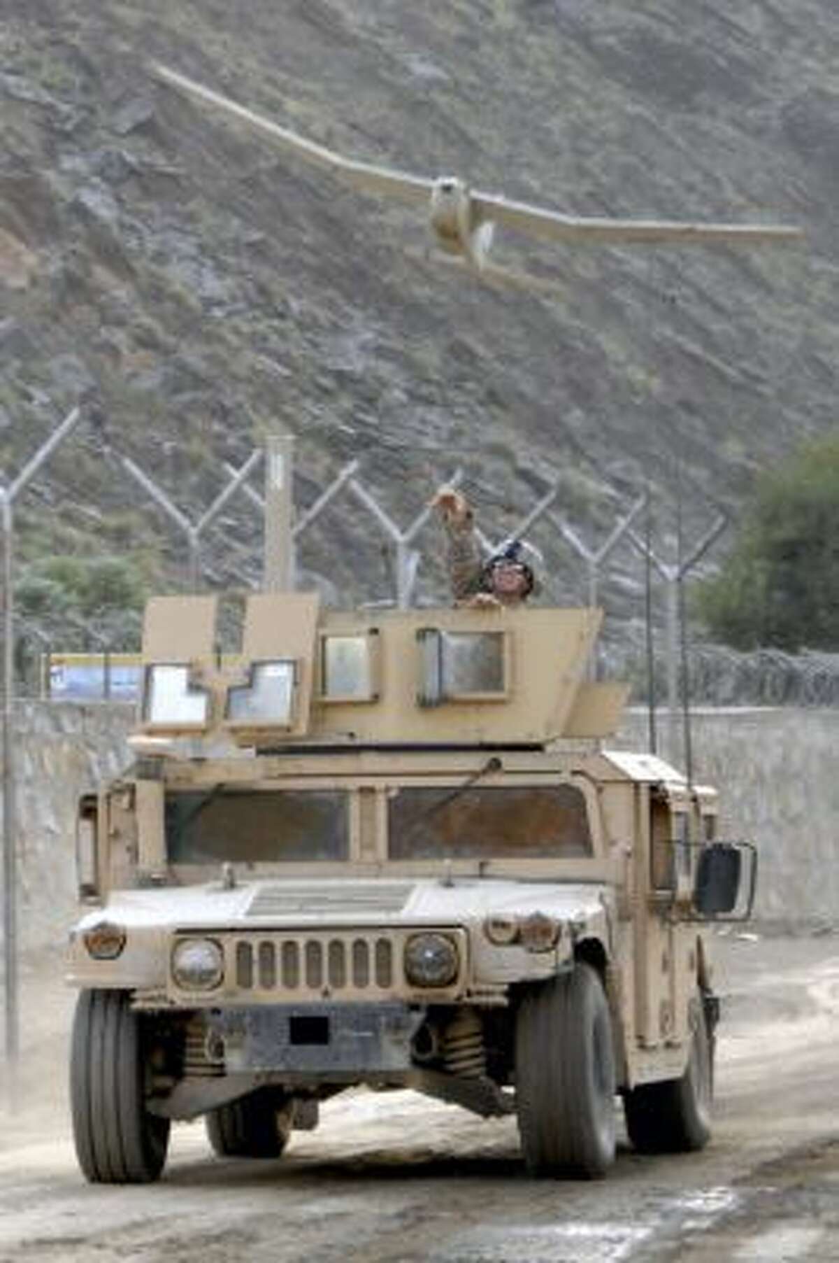 Staff Sergeant Justin McDaniel tosses an Aerovironment Inc. Puma AE unmanned aerial vehicle (UAV) into the air from a moving Humvee during training on the UAV at Forward Operating Base Blessing, Afghanistan, on Oct. 7, 2009. Aerovironment, a maker of small surveillance drones, surprised investors on March 5 by reporting an unprecedented slowdown in military orders.
