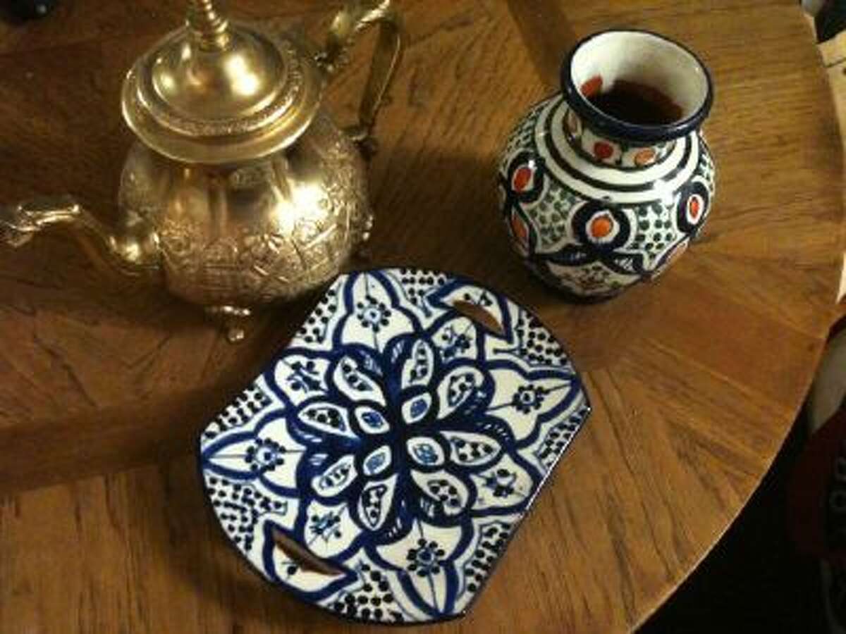 A tea pot, purchased in Essaouira, Morocco, and a ceramic vase and plate, purchased in Marrakech, Morocco, by Maura Judkis and Scott Gilmore in July, shown here in their house in Washington in October. The tea pot was haggled for, but the vase and plate were purchased in a fixed-price store.